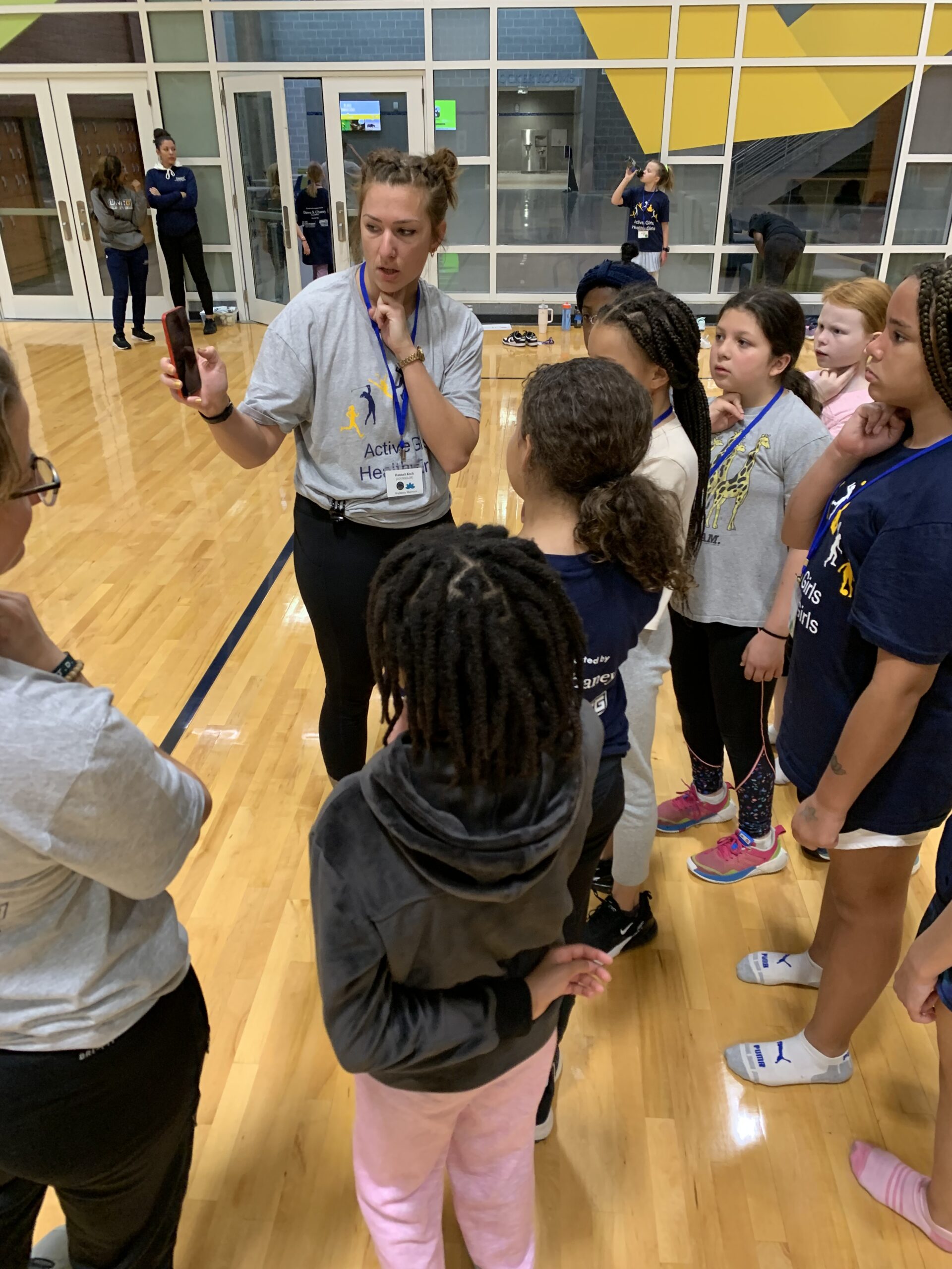 Camp counselors teaching girls how to measure their heart rate