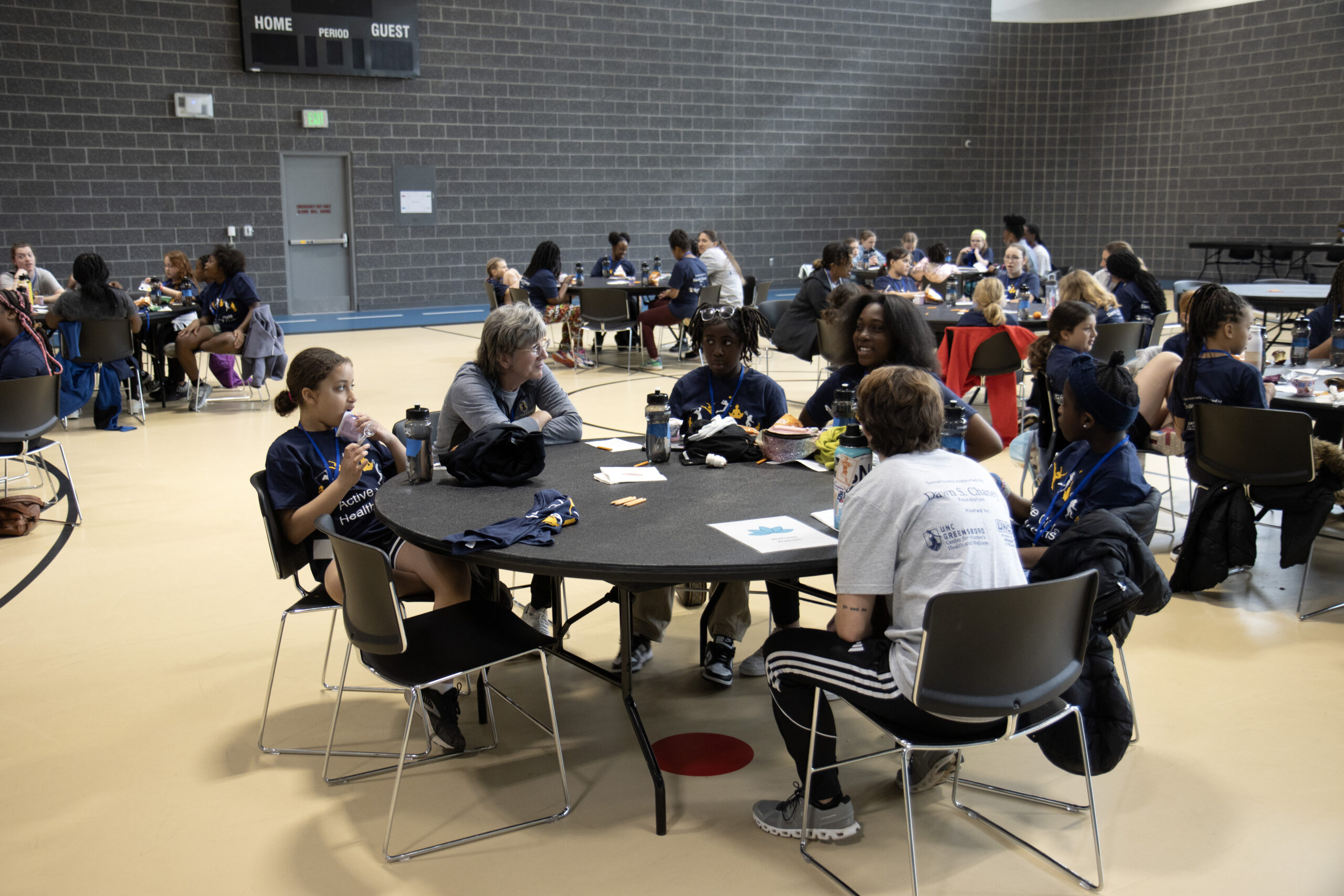 A table of girls and camp leaders discussing a topic