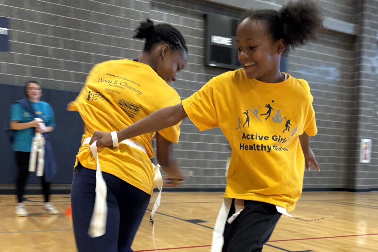 Two AGHG campers playing flag football, trying to get each oters' flags.